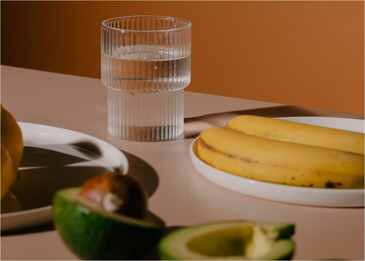 Wasser, Banane, Avocado auf Tisch